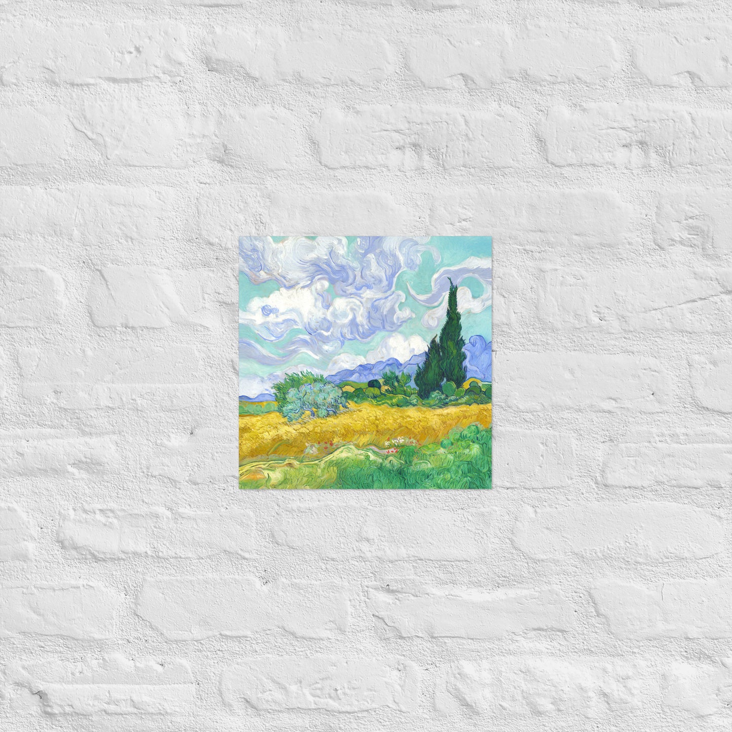 Van Gogh's 'Wheat Field with Cypresses' on a 12"x12" unframed poster print on a white brick wall.