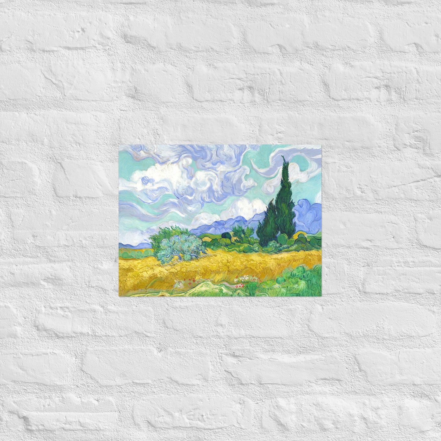 Van Gogh's 'Wheat Field with Cypresses' on a 12"x16" unframed poster print on a white brick wall.