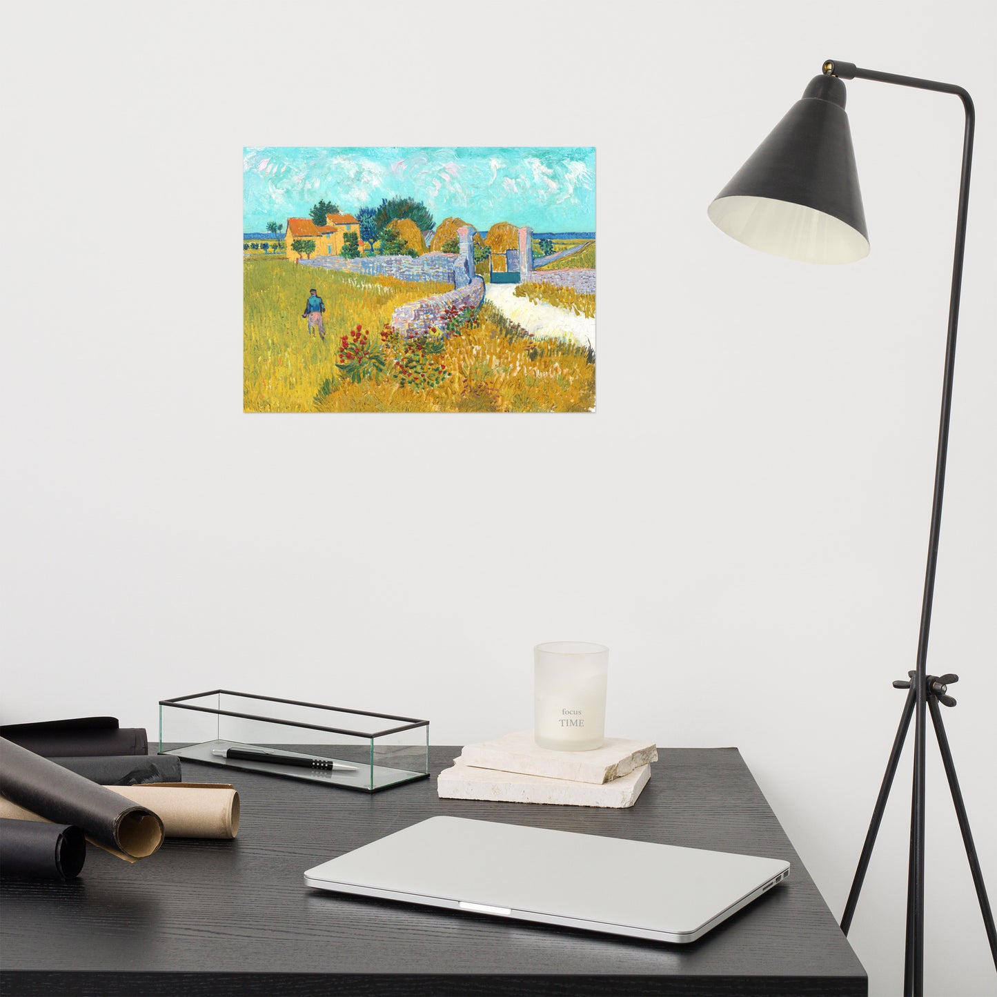 Van Gogh's 'Farmhouse in Provence' on a 12"x16" unframed poster print on a white wall above a modern office desk, lamp, and assorted desk items.