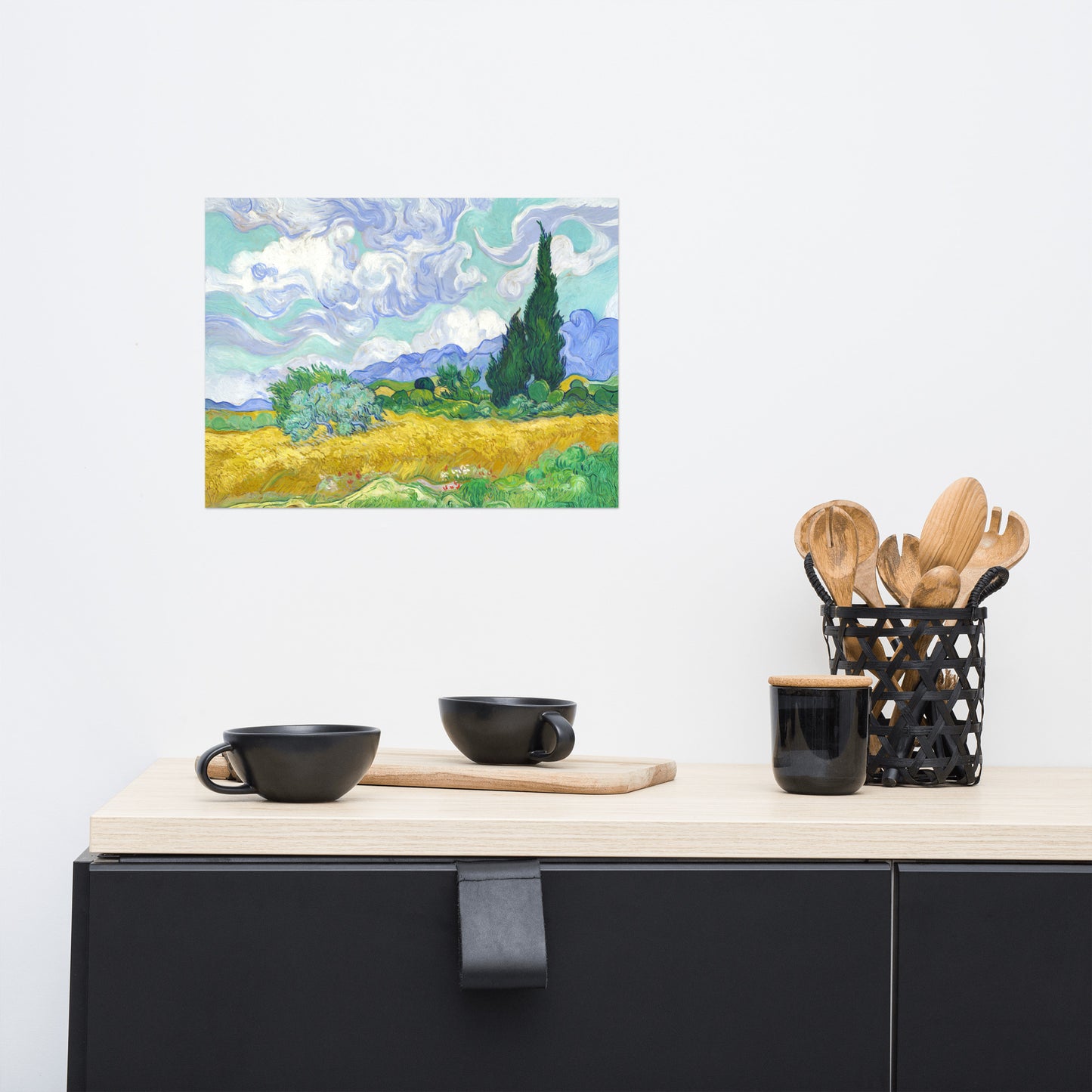 Van Gogh's 'Wheat Field with Cypresses' on a 12"x16" unframed poster print on a white wall above a kitchen counter with cooking supplies.
