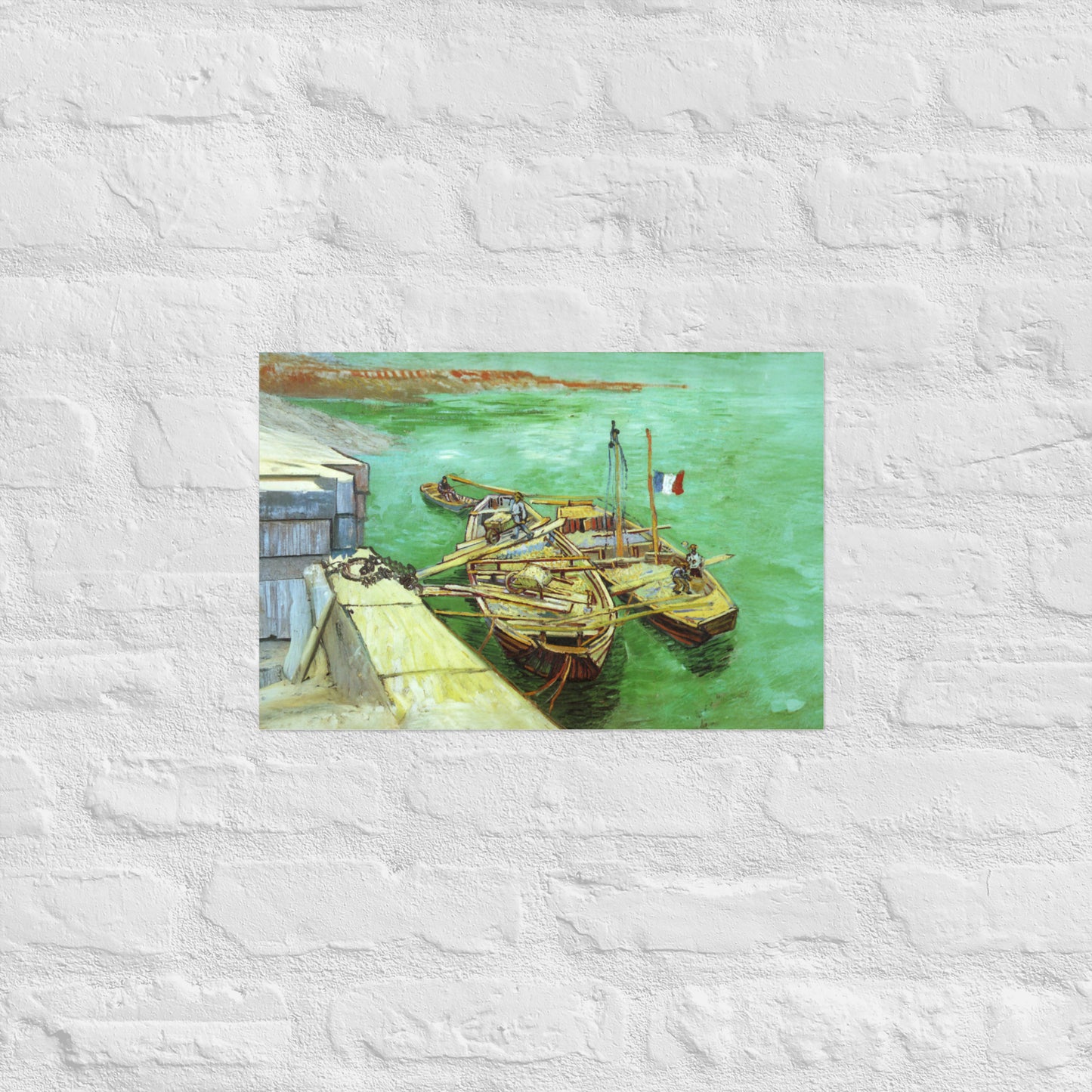 Van Gogh's 'Quay with Men Unloading Sand Barges' on a 12"x18" unframed poster print on a white brick wall.