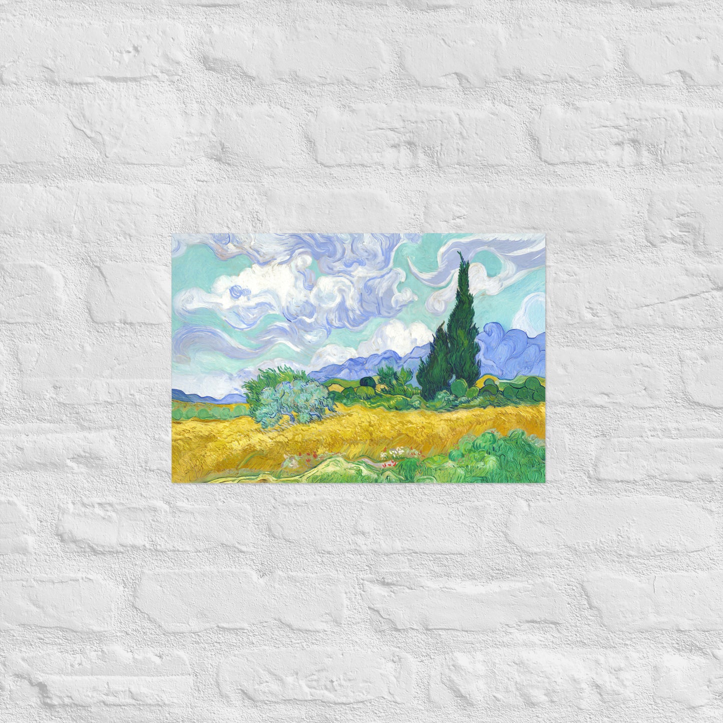 Van Gogh's 'Wheat Field with Cypresses' on a 12"x18" unframed poster print on a white brick wall.
