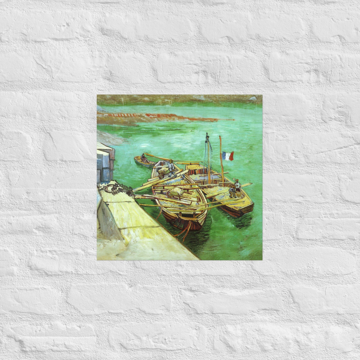 Van Gogh's 'Quay with Men Unloading Sand Barges' on a 16"x16" unframed poster print on a white brick wall.
