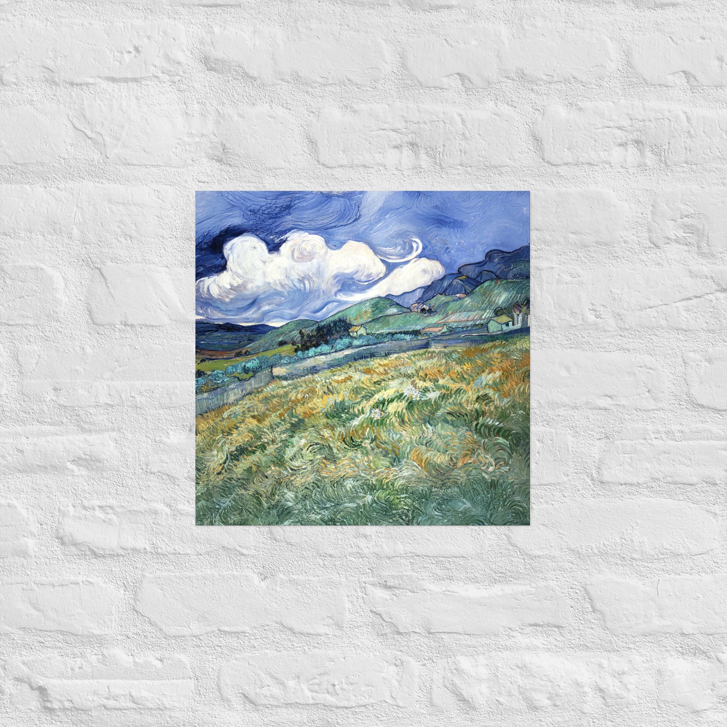 Van Gogh's 'Landscape from Saint-Rémy' on a 16"x16" unframed poster print on a white brick wall.