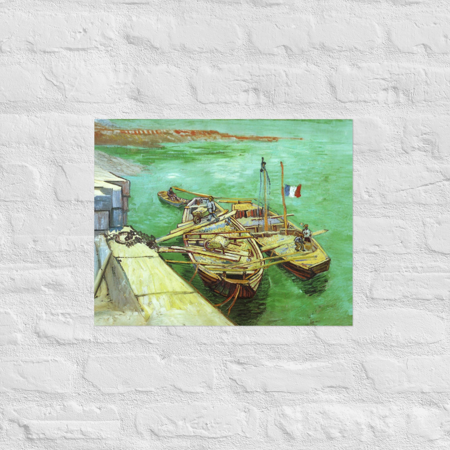 Van Gogh's 'Quay with Men Unloading Sand Barges' on a 16"x20" unframed poster print on a white brick wall.