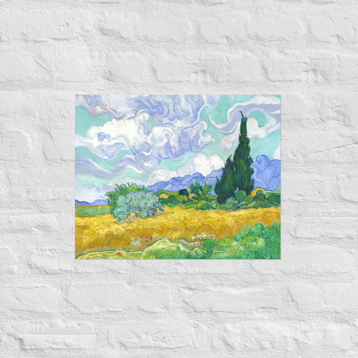 Van Gogh's 'Wheat Field with Cypresses' on a 16"x20" unframed poster print on a white brick wall.
