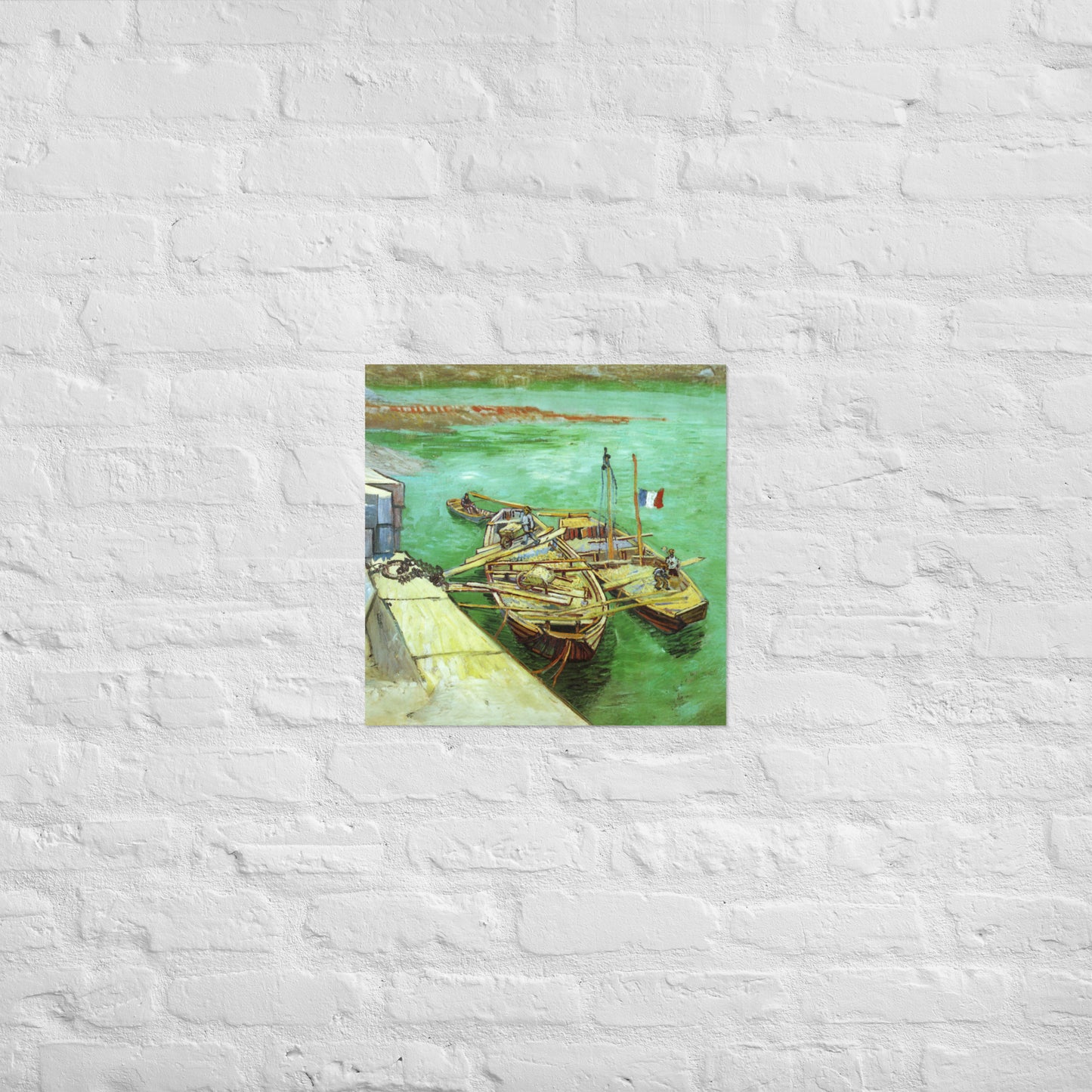 Van Gogh's 'Quay with Men Unloading Sand Barges' on a 18"x18" unframed poster print on a white brick wall.