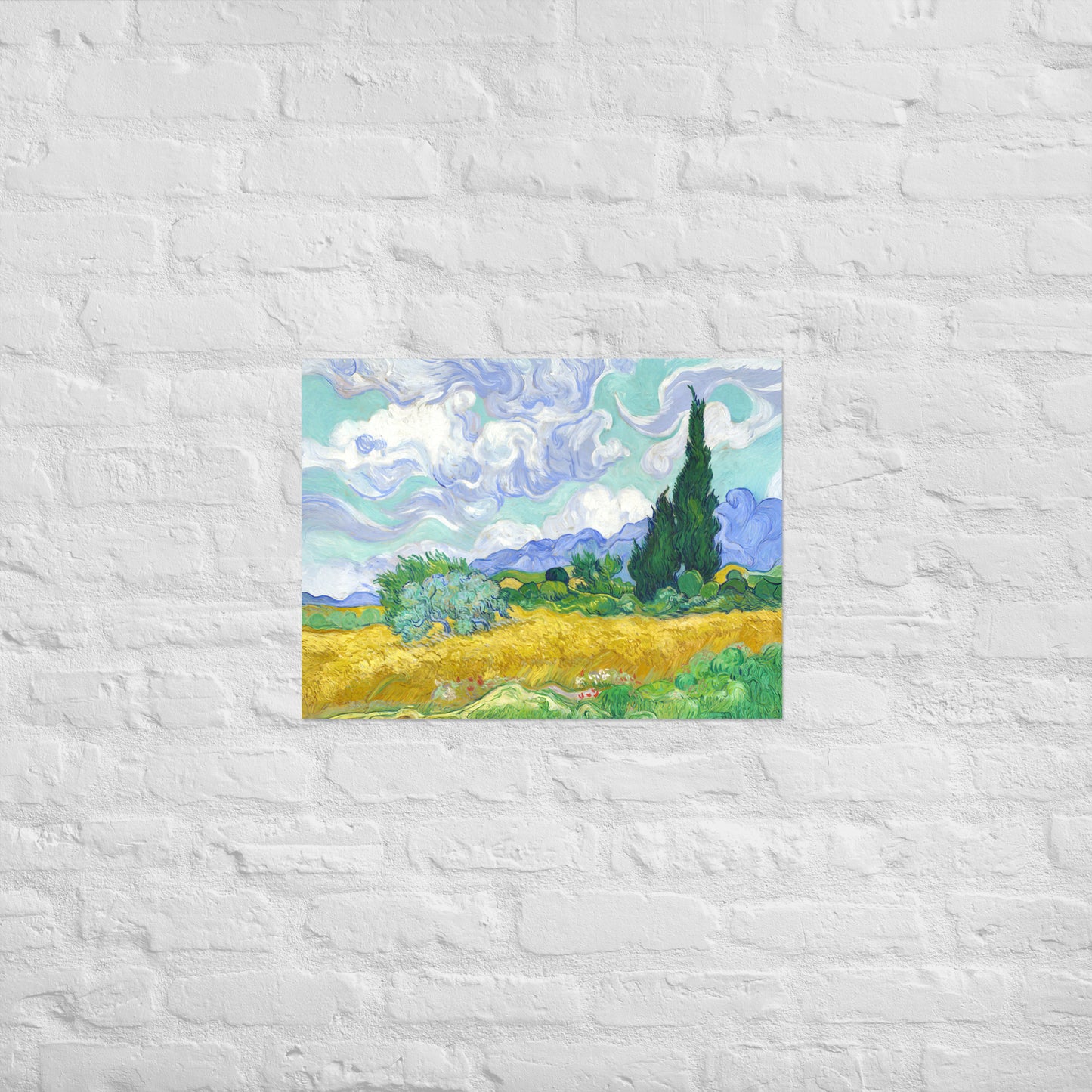 Van Gogh's 'Wheat Field with Cypresses' on a 18"x24" unframed poster print on a white brick wall.