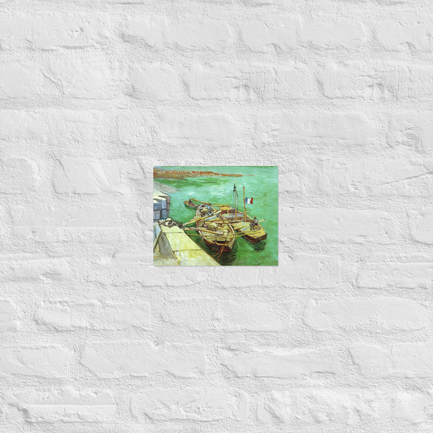 Van Gogh's 'Quay with Men Unloading Sand Barges' on a 8"x10" unframed poster print on a white brick wall.