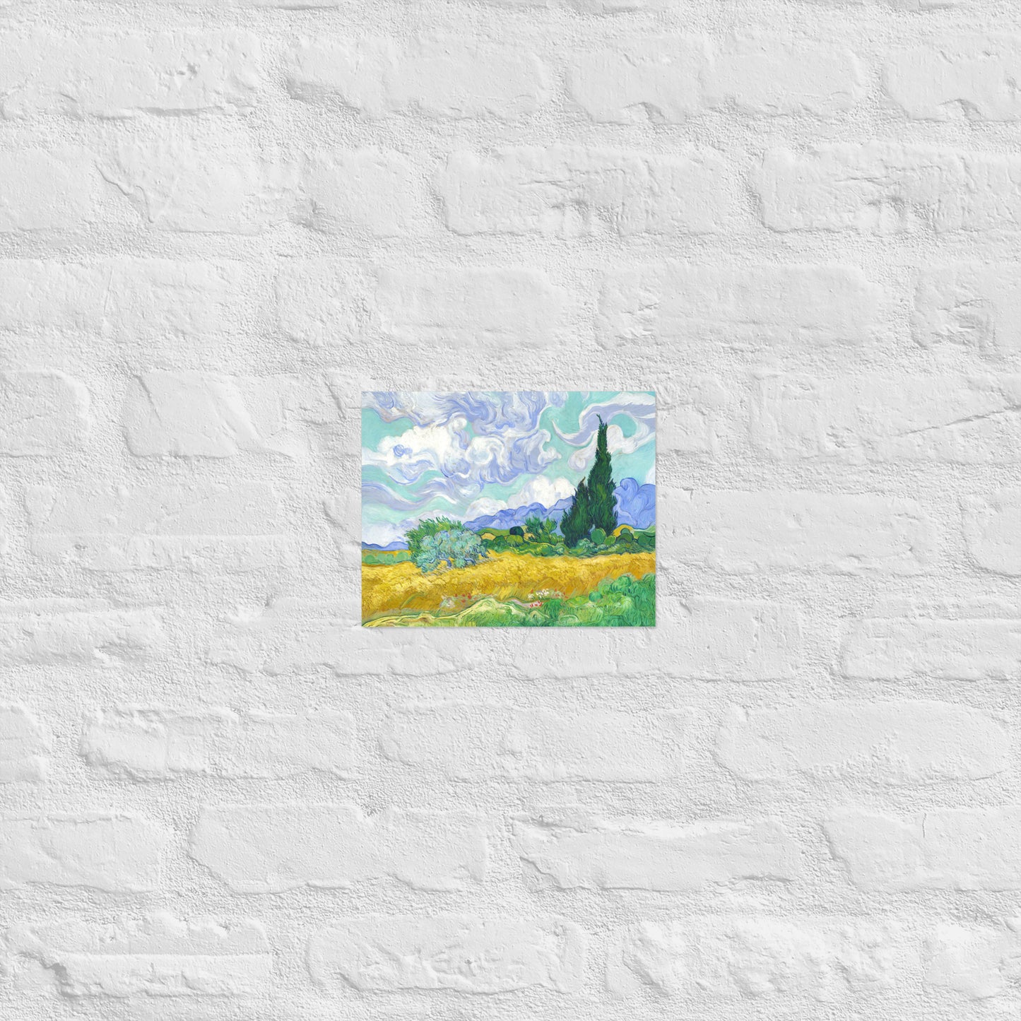 Van Gogh's 'Wheat Field with Cypresses' on a 8"x10" unframed poster print on a white brick wall.