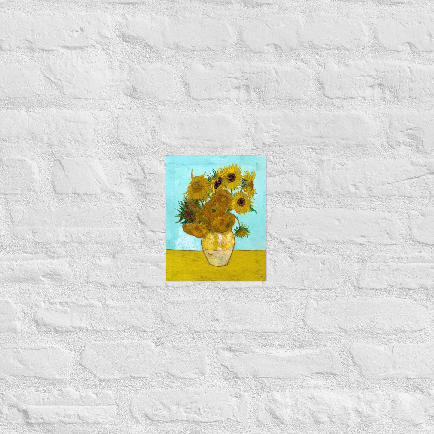 Van Gogh's 'Vase with Twelve Sunflowers' on a 8"x10" unframed poster print on a white brick wall.
