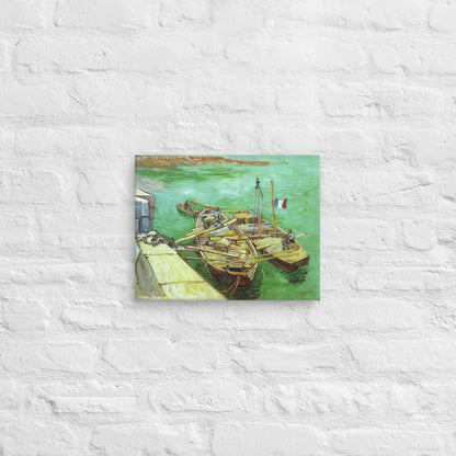 Van Gogh's 'Quay with Men Unloading Sand Barges' on a 11"x14" unframed canvas print on a white brick wall.