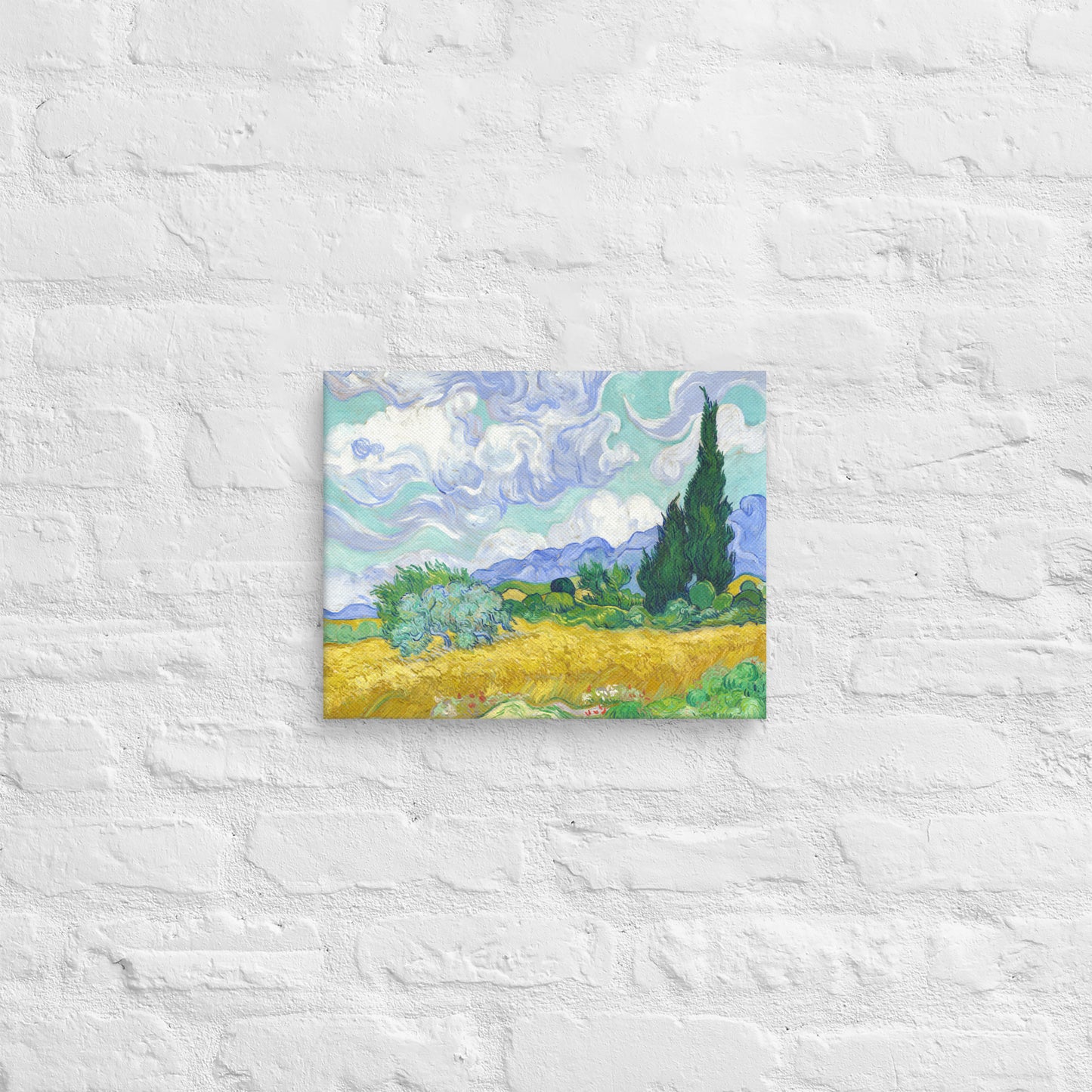 Van Gogh's 'Wheat Field with Cypresses' on a 11"x14" unframed canvas print on a white brick wall.