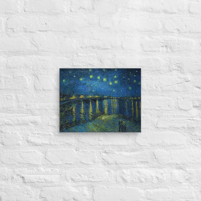 Van Gogh's 'Starry Night Over the Rhone' on a 11"x14" unframed canvas print on a white brick wall.