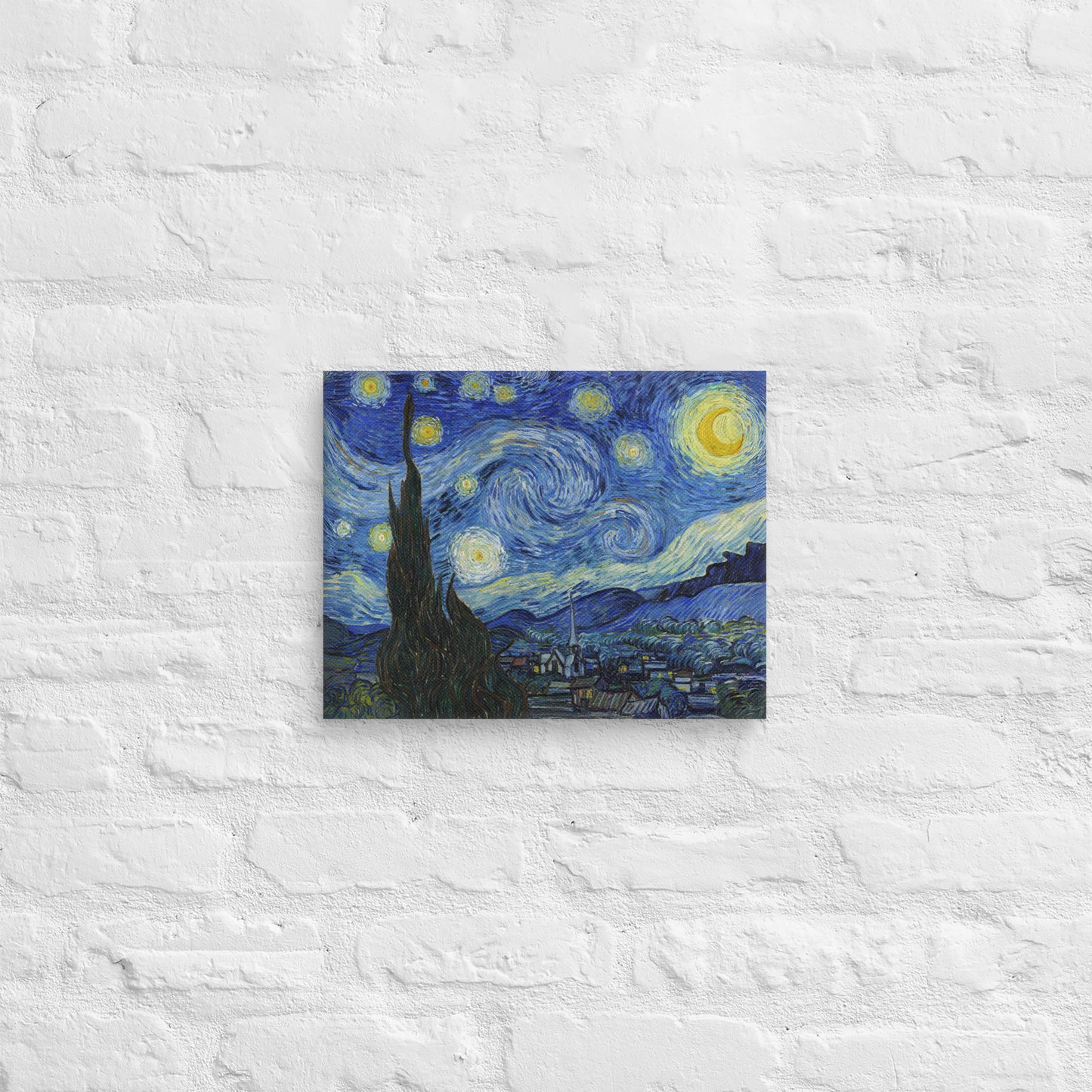 Van Gogh's 'Starry Night' on a 11"x14" unframed canvas print on a white brick wall.