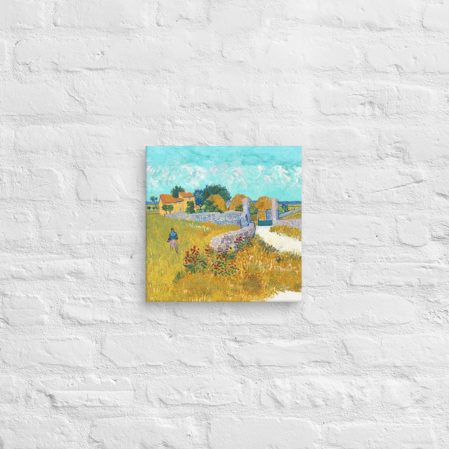 Van Gogh's 'Farmhouse in Provence' on a 12"x12" unframed canvas print on a white brick wall.