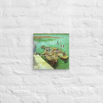 Van Gogh's 'Quay with Men Unloading Sand Barges' on a 12"x12" unframed canvas print on a white brick wall.