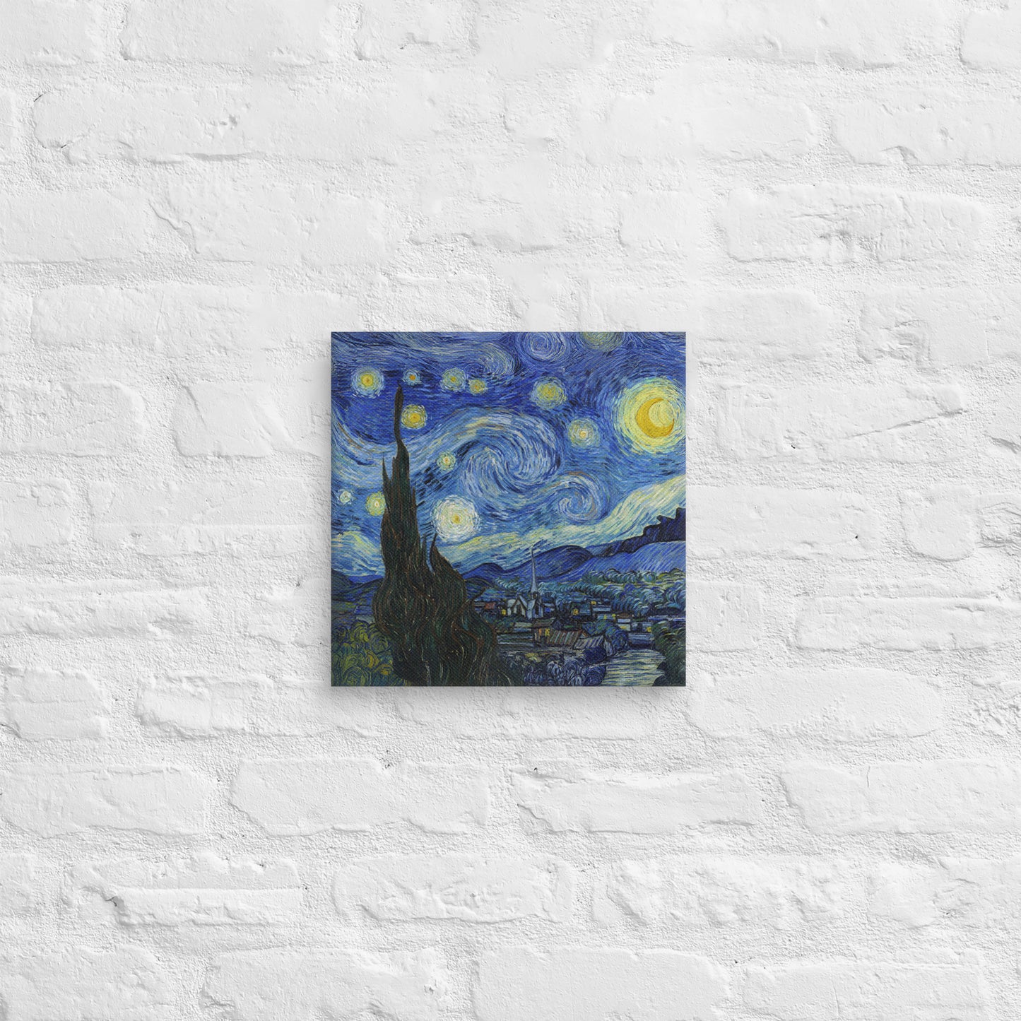 Van Gogh's 'Starry Night' on a 12"x12" unframed canvas print on a white brick wall.