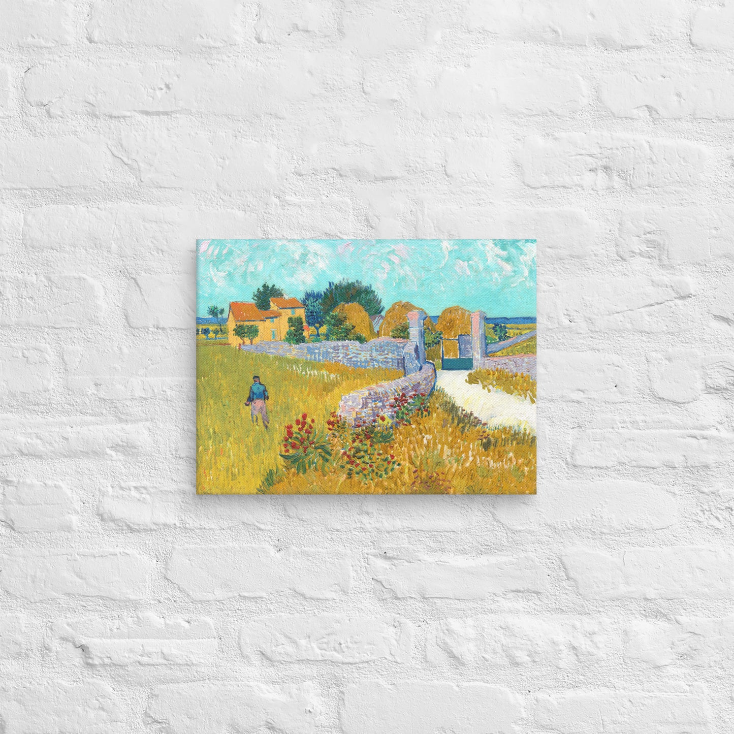 Van Gogh's 'Farmhouse in Provence' on a 12"x16" unframed canvas print on a white brick wall.