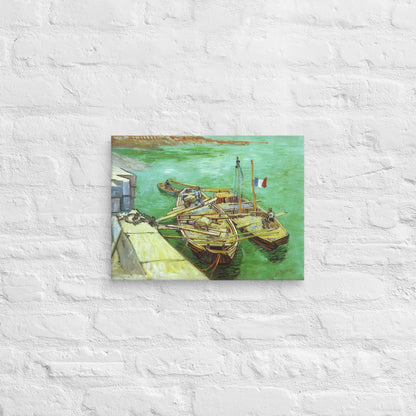 Van Gogh's 'Quay with Men Unloading Sand Barges' on a 12"x16" unframed canvas print on a white brick wall.