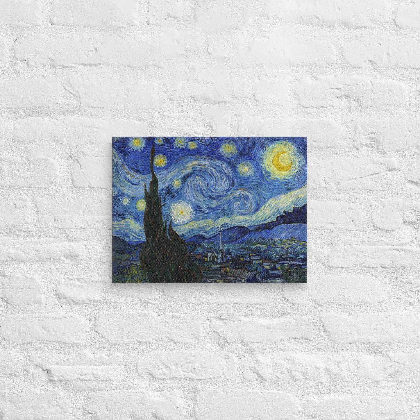 Van Gogh's 'Starry Night' on a 12"x16" unframed canvas print on a white brick wall.