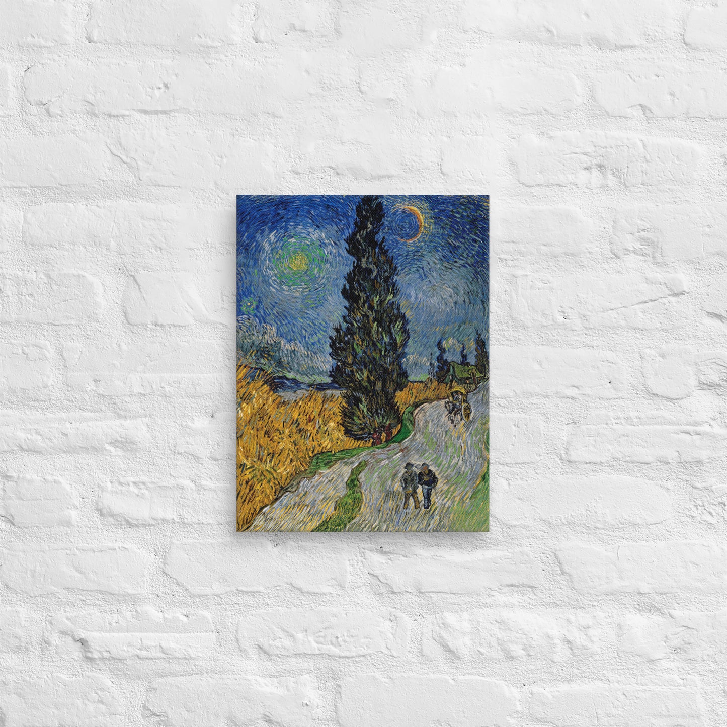 Van Gogh's 'Road with Cypress and Star' on a 12"x16" unframed canvas print on a white brick wall.