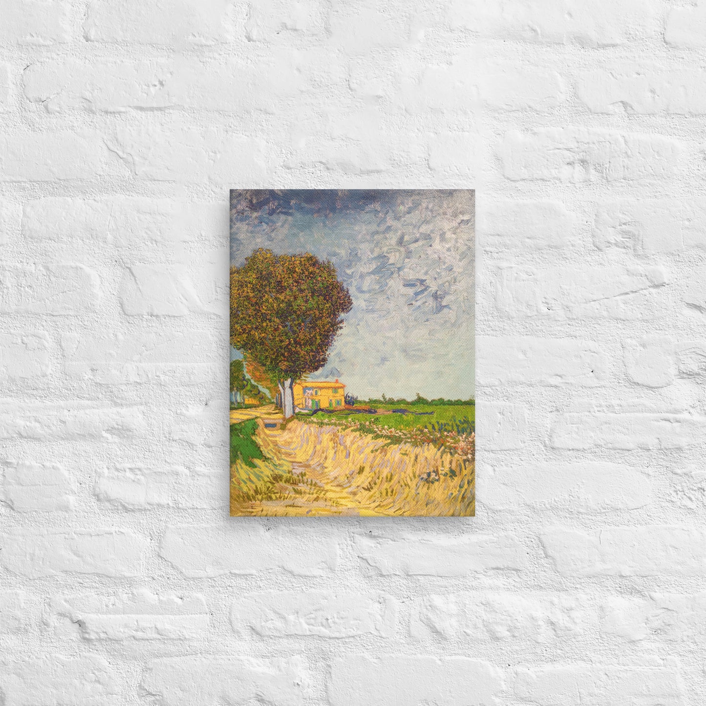 Van Gogh's 'A Lane near Arles' on a 12"x16" unframed canvas print on a white brick wall.