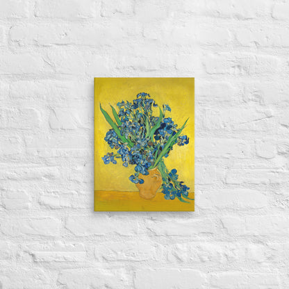 Van Gogh's 'Vase with Irises Against a Yellow Background' on a 12"x16" unframed canvas print on a white brick wall.