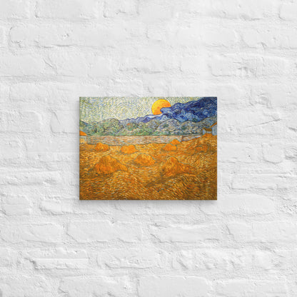 Van Gogh's 'Landscape with Wheat Sheaves and Rising Moon' on a 12"x16" unframed canvas print on a white brick wall.