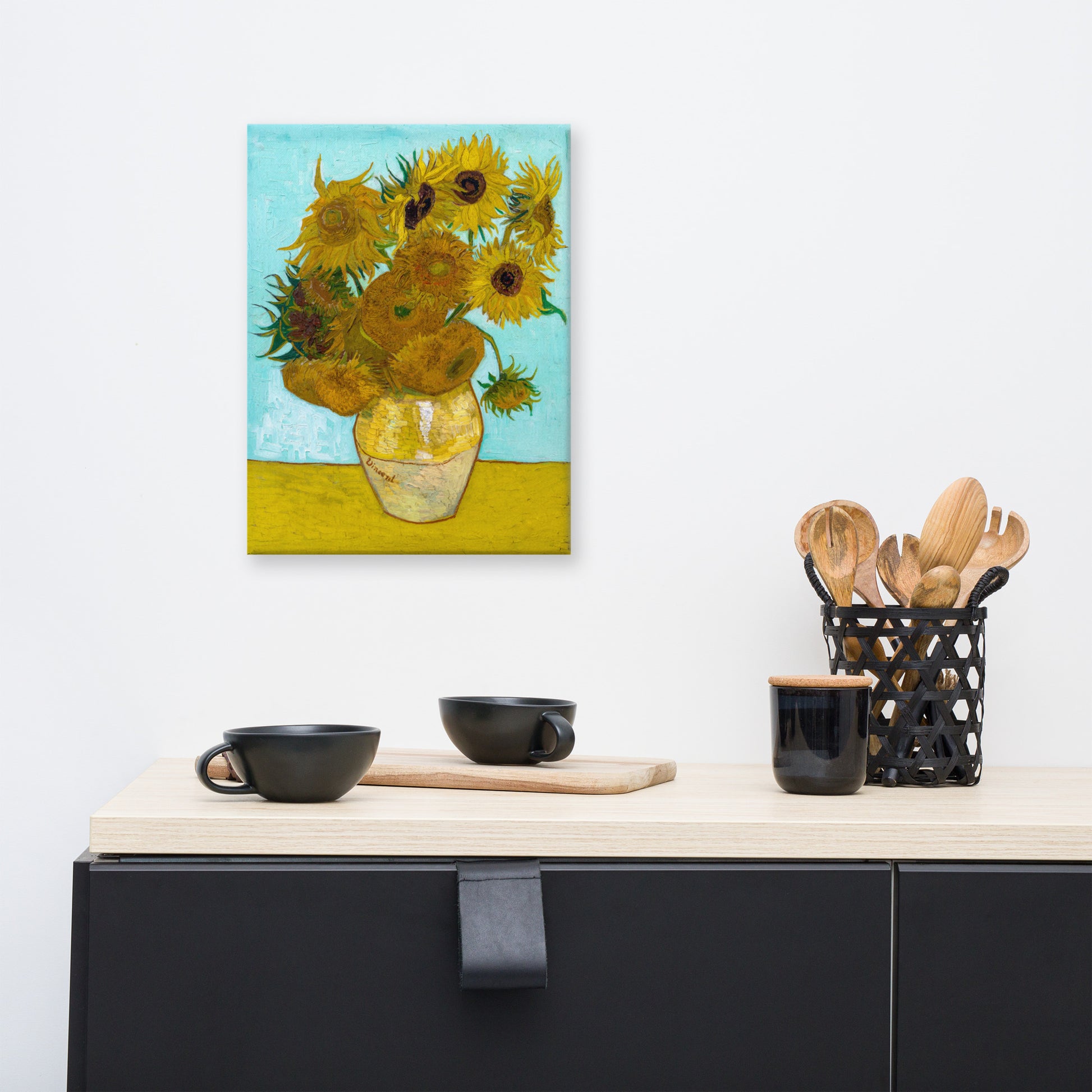 Van Gogh's 'Vase with Twelve Sunflowers' on a 12"x16" unframed canvas print on a white wall above a kitchen counter with cooking supplies.