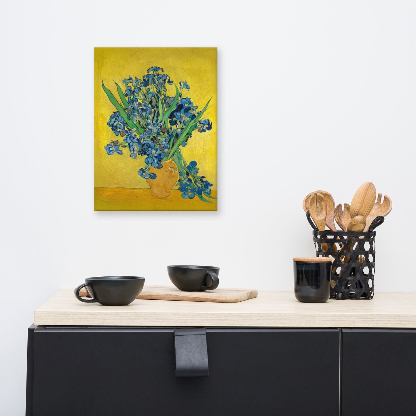 Van Gogh's 'Vase with Irises Against a Yellow Background' on a 12"x16" unframed canvas print on a white wall above a kitchen counter with cooking supplies.