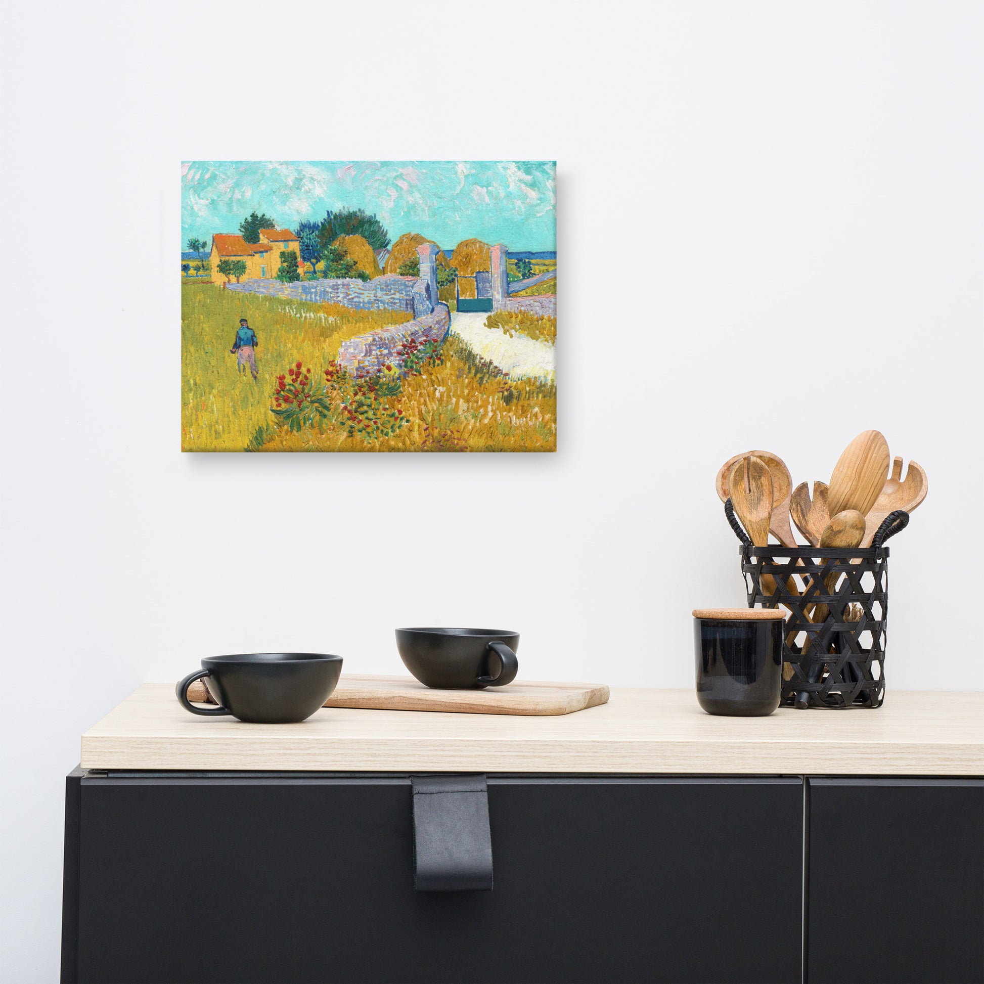 Van Gogh's 'Farmhouse in Provence' on a 12"x16" unframed canvas print on a white wall above a kitchen counter with cooking supplies.