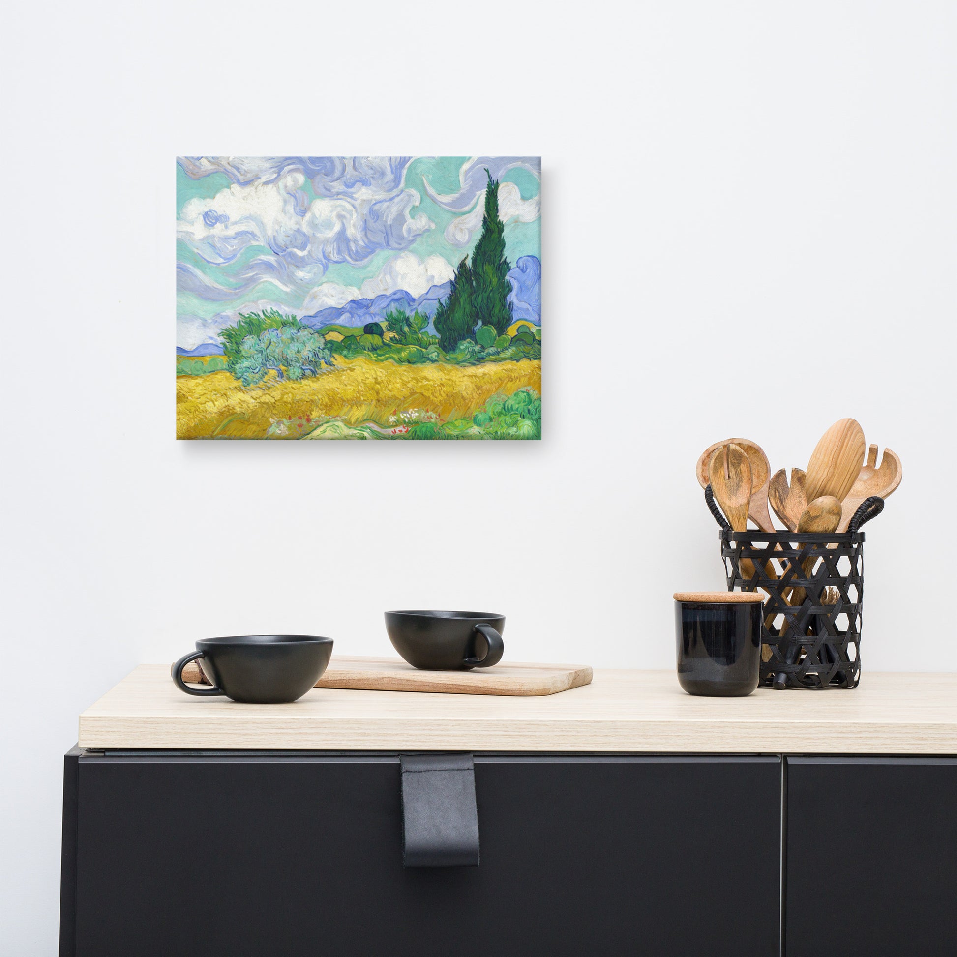 Van Gogh's 'Wheat Field with Cypresses' on a 12"x16" unframed canvas print on a white wall above a kitchen counter with cooking supplies.