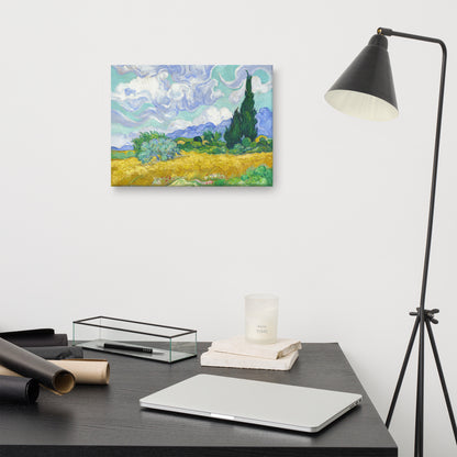 Van Gogh's 'Wheat Field with Cypresses' on a 12"x16" unframed canvas print on a white wall above a modern office desk, lamp, and assorted desk items.