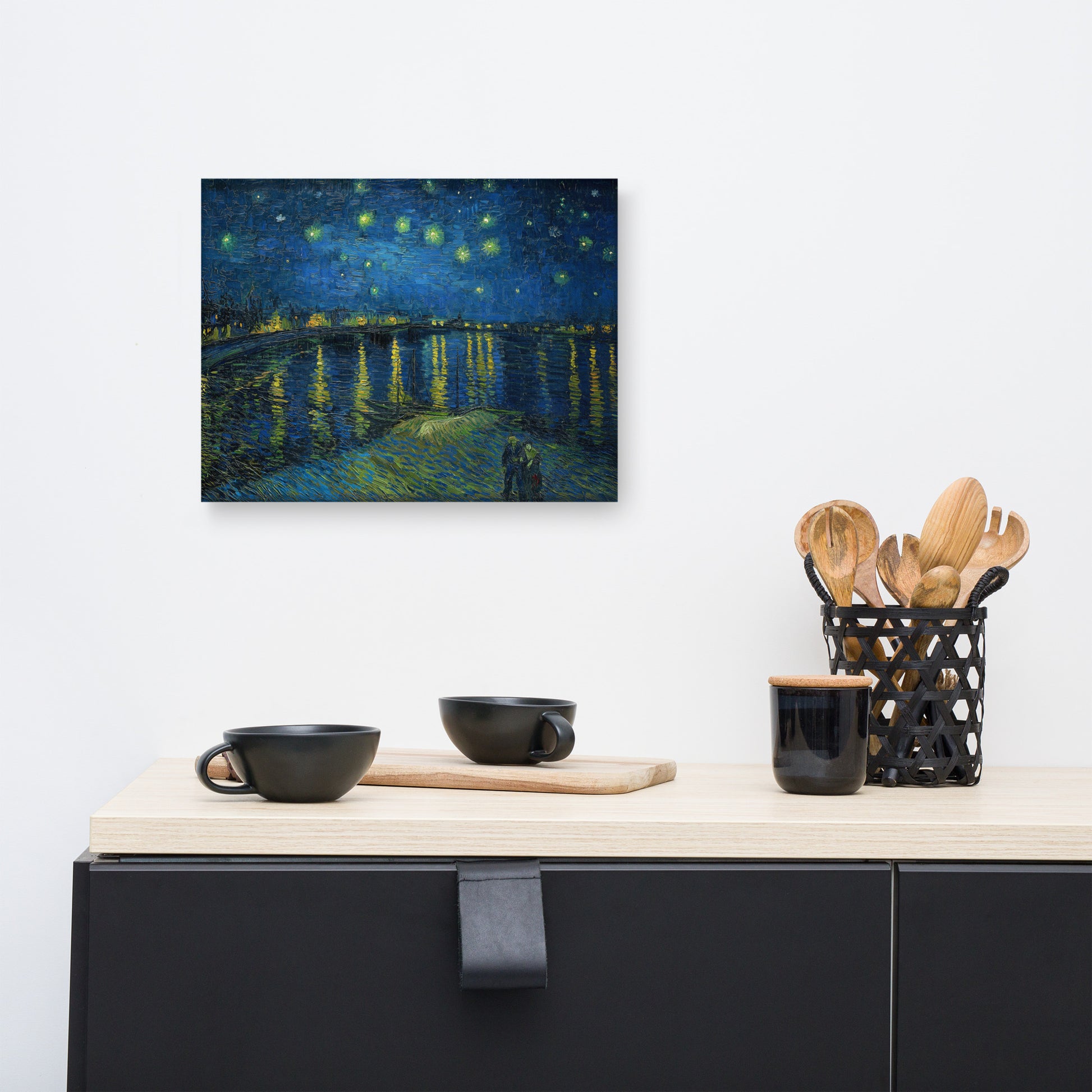 Van Gogh's 'Starry Night Over the Rhone' on a 12"x16" unframed canvas print on a white wall above a kitchen counter with cooking supplies.