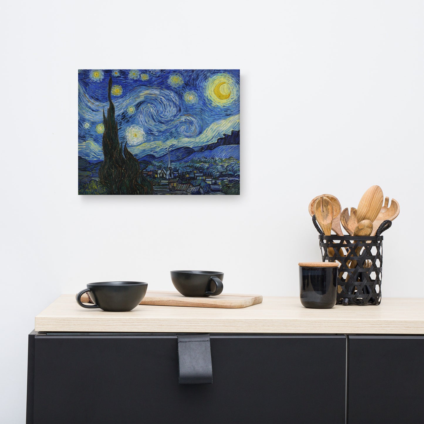 Van Gogh's 'Starry Night' on a 12"x16" unframed canvas print on a white wall above a kitchen counter with cooking supplies.