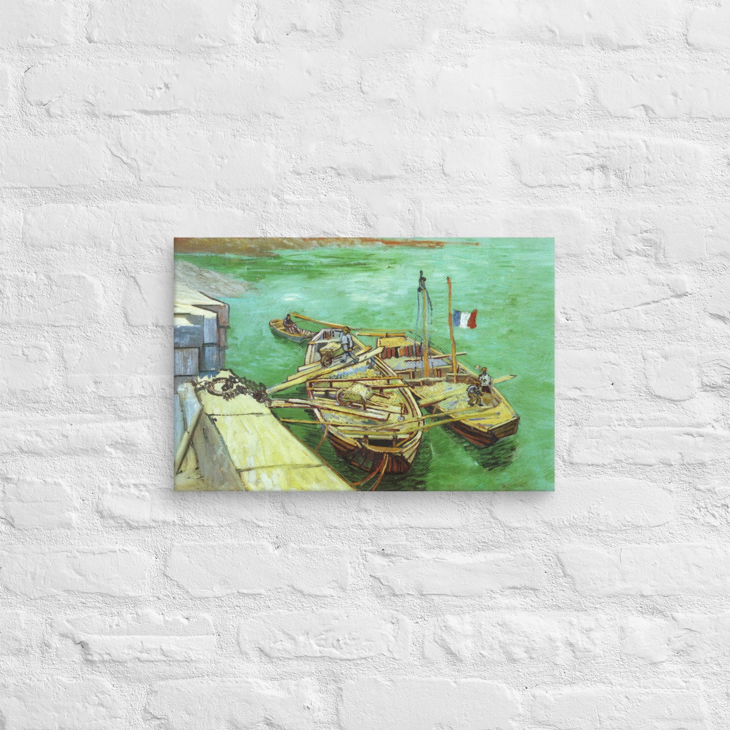 Van Gogh's 'Quay with Men Unloading Sand Barges' on a 12"x18" unframed canvas print on a white brick wall.