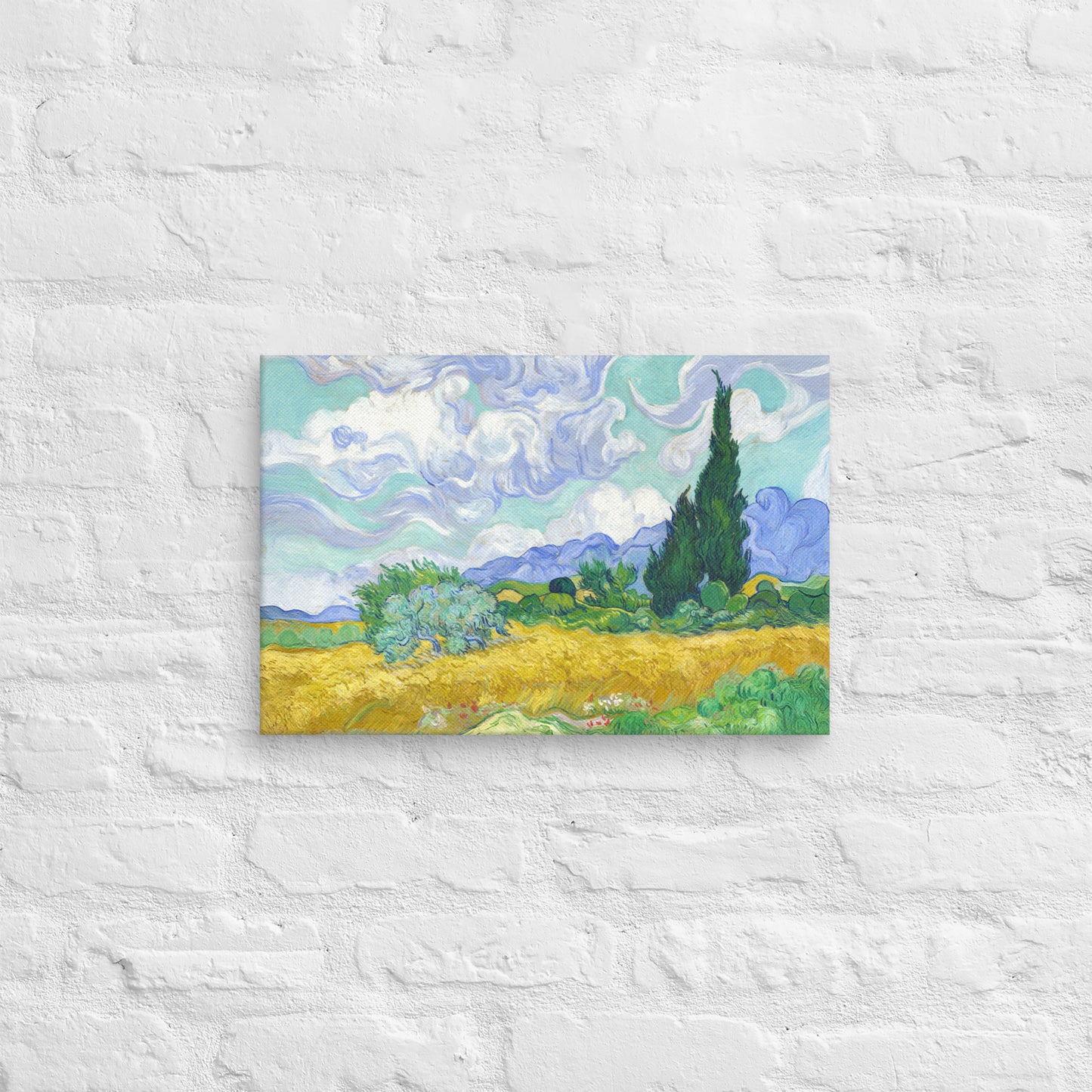 Van Gogh's 'Wheat Field with Cypresses' on a 12"x18" unframed canvas print on a white brick wall.