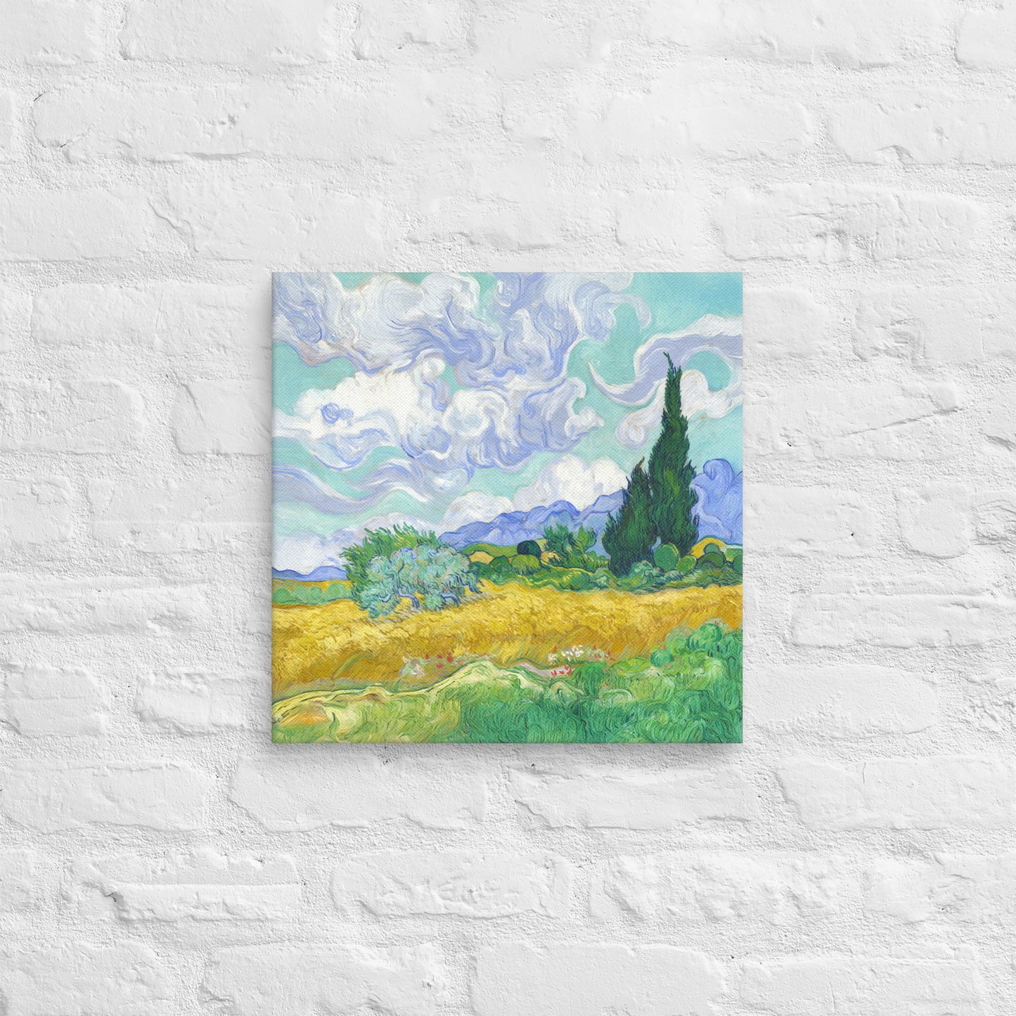Van Gogh's 'Wheat Field with Cypresses' on a 16"x16" unframed canvas print on a white brick wall.