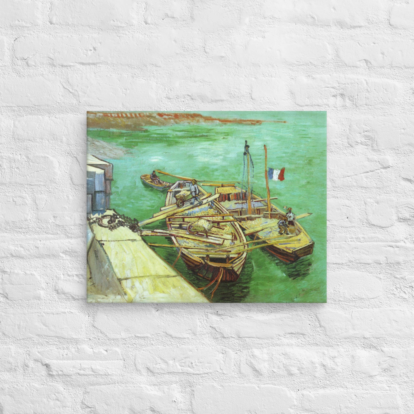 Van Gogh's 'Quay with Men Unloading Sand Barges' on a 16"x20" unframed canvas print on a white brick wall.