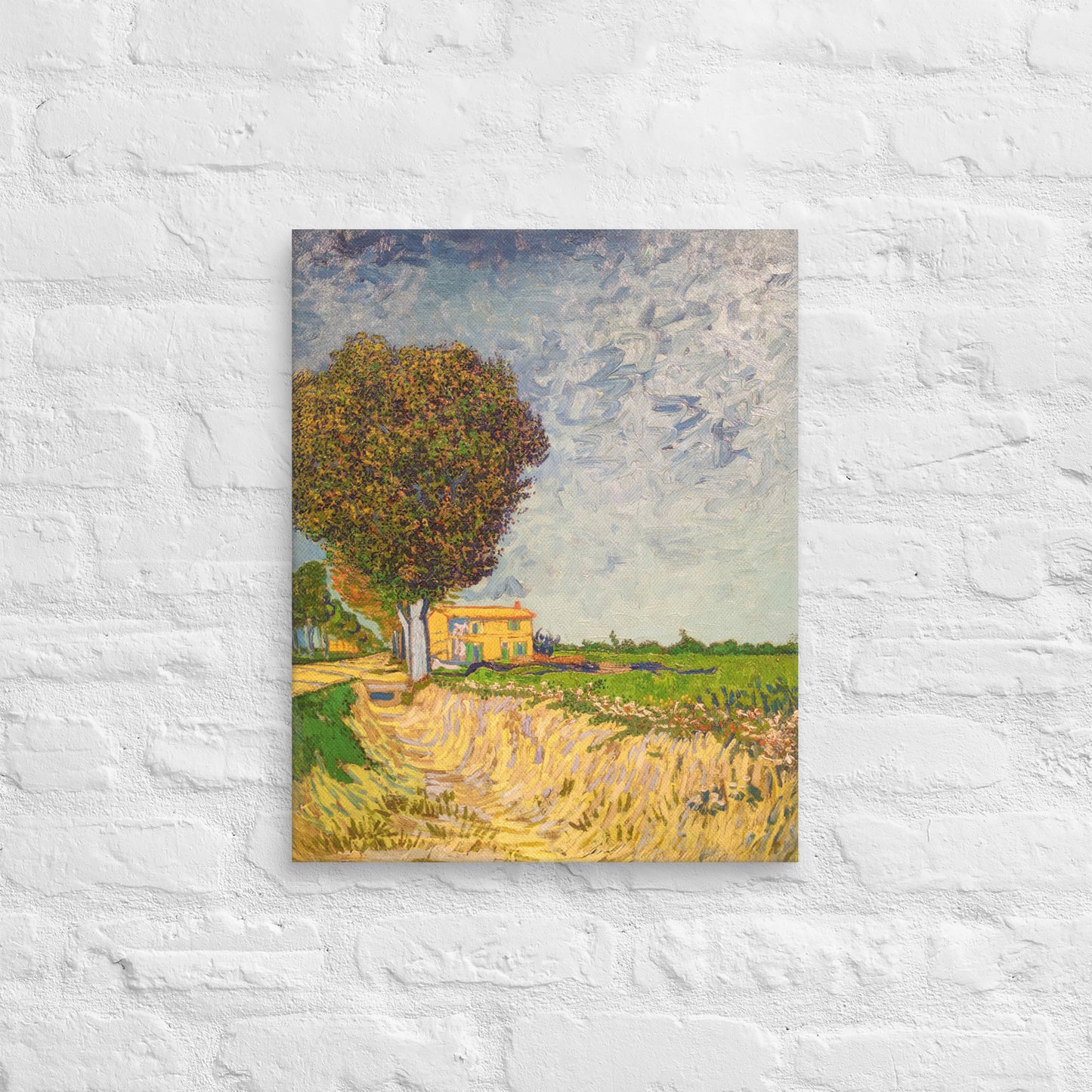 Van Gogh's 'A Lane near Arles' on a 16"x20" unframed canvas print on a white brick wall.