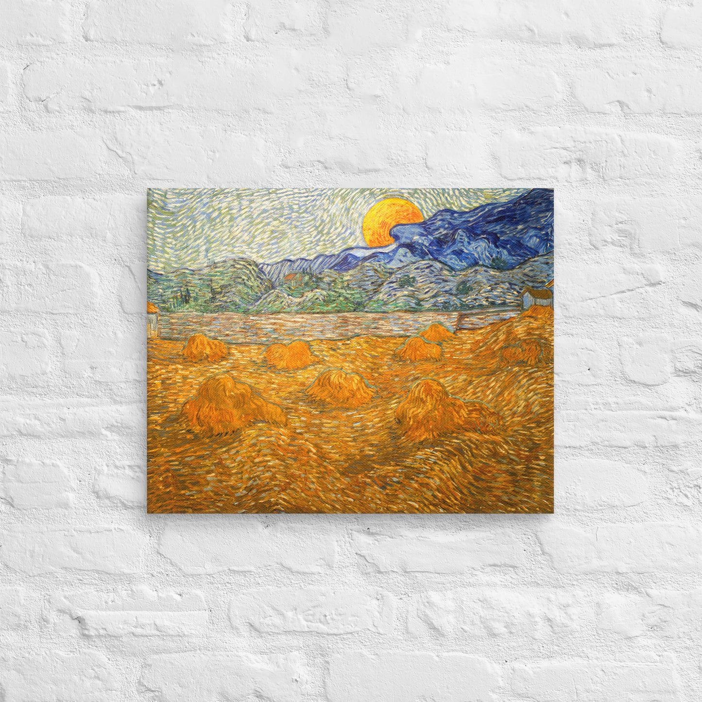Van Gogh's 'Landscape with Wheat Sheaves and Rising Moon' on a 16"x20" unframed canvas print on a white brick wall.