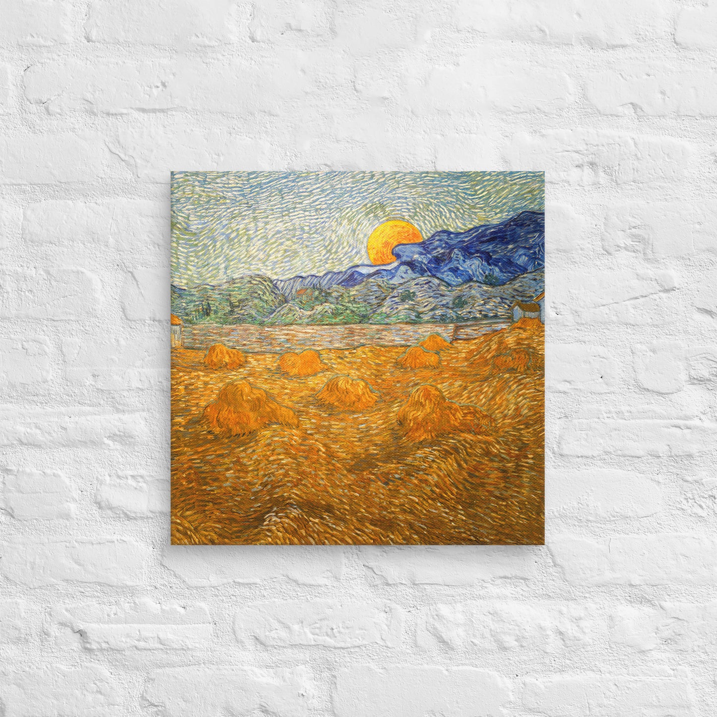 Van Gogh's 'Landscape with Wheat Sheaves and Rising Moon' on a 18"x18" unframed canvas print on a white brick wall.