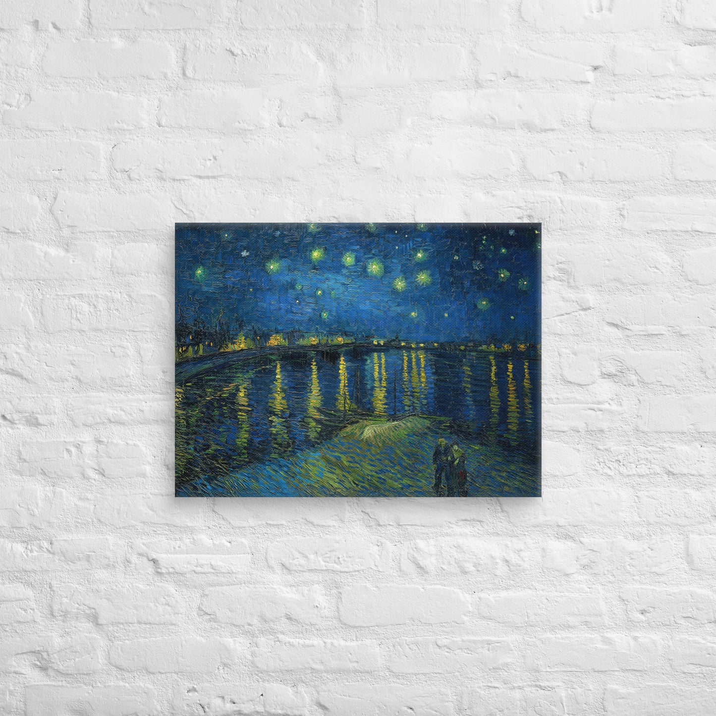 Van Gogh's 'Starry Night Over the Rhone' on a 18"x24" unframed canvas print on a white brick wall.