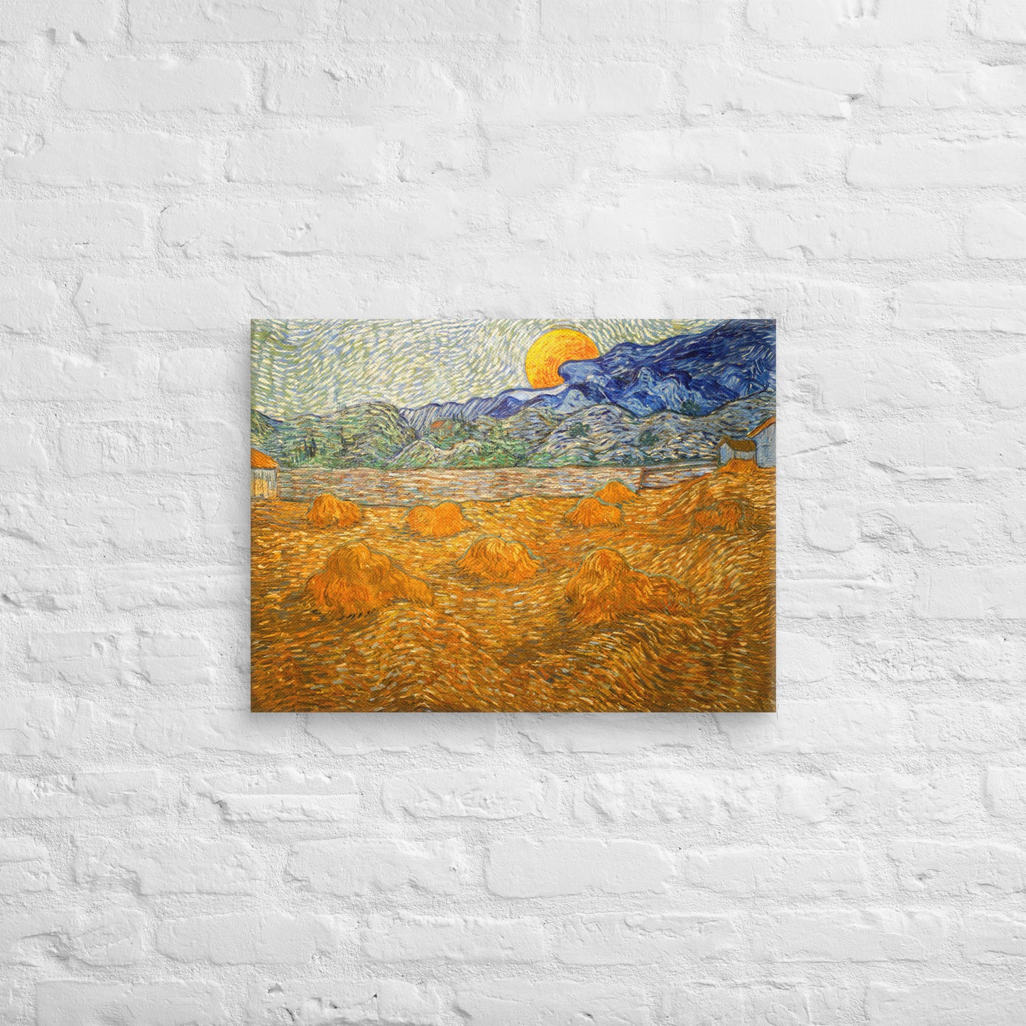 Van Gogh's 'Landscape with Wheat Sheaves and Rising Moon' on a 18"x24" unframed canvas print on a white brick wall.