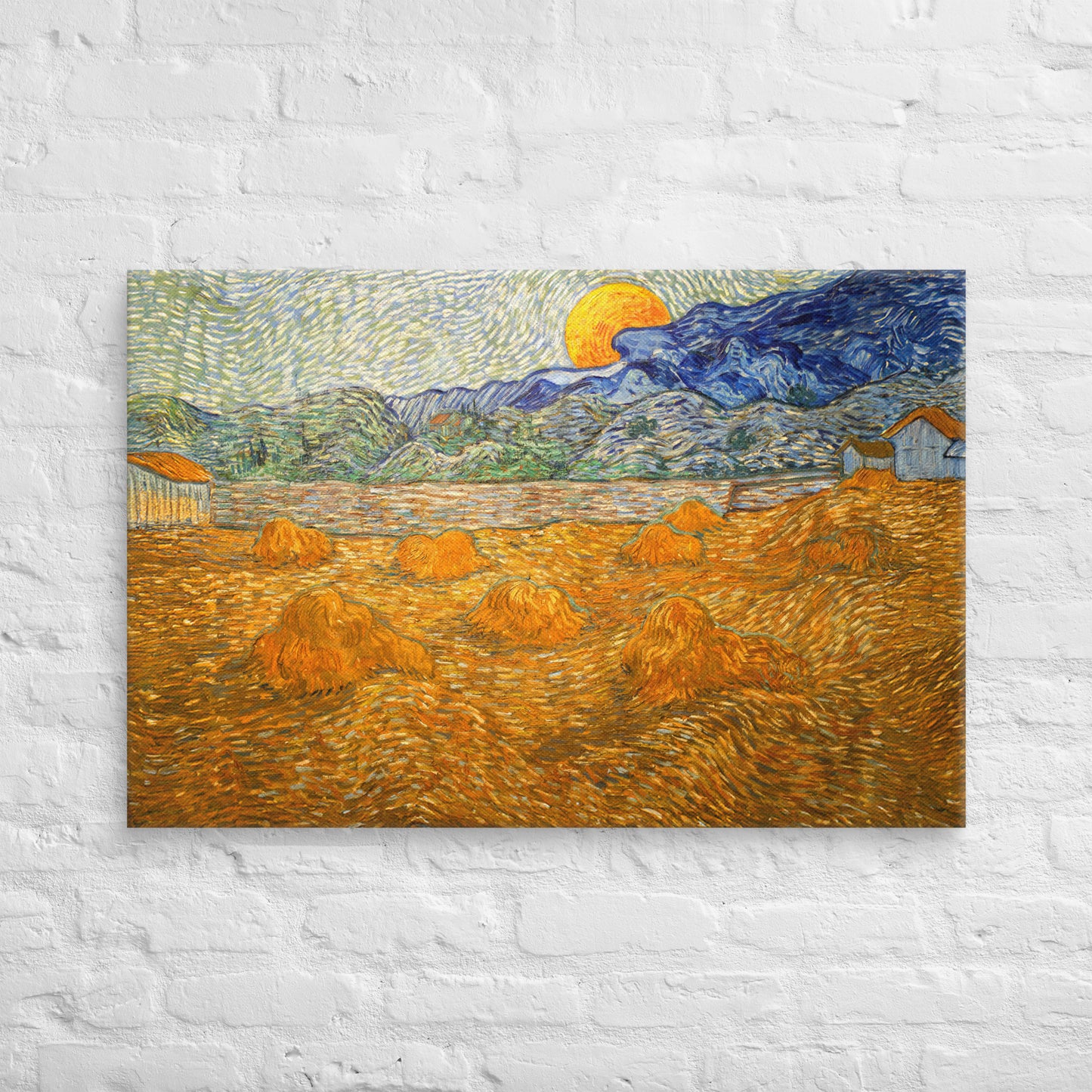 Van Gogh's 'Landscape with Wheat Sheaves and Rising Moon' on a 24"x36" unframed canvas print on a white brick wall.