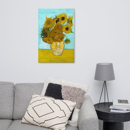 Van Gogh's 'Vase with Twelve Sunflowers' on a 24"x36" unframed canvas print on a white wall above a gray sofa with throw pillows and side table with a lamp.
