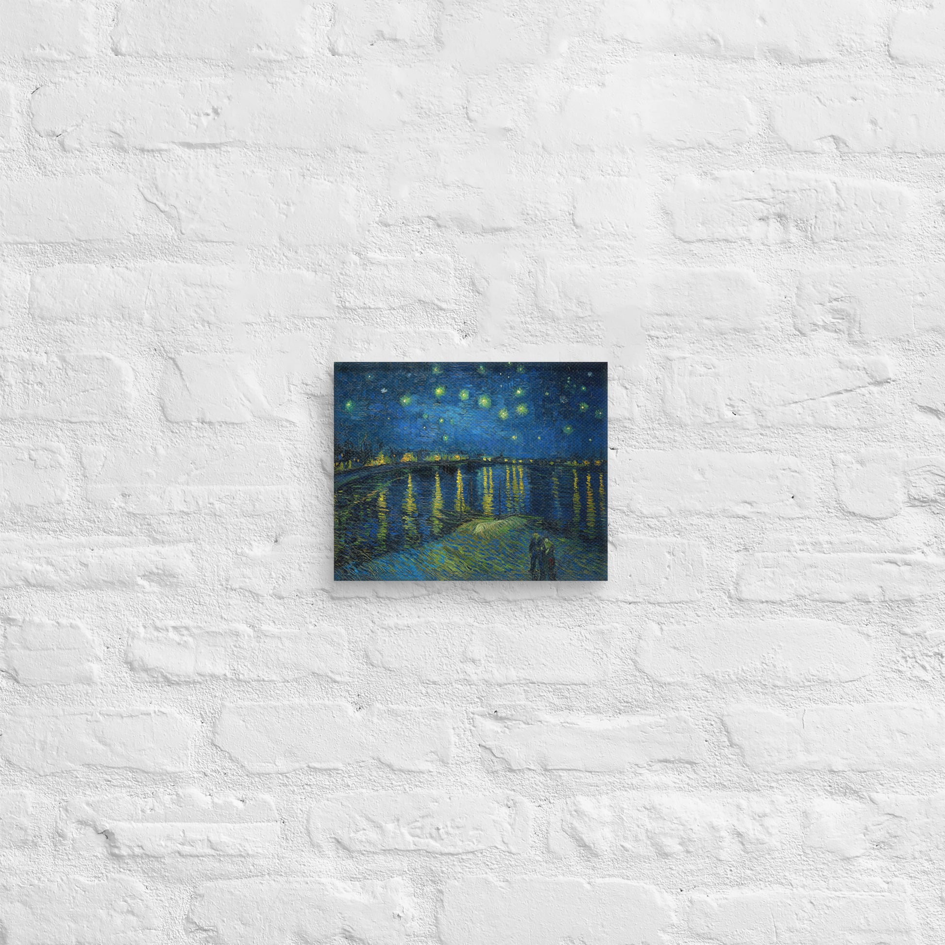 Van Gogh's 'Starry Night Over the Rhone' on a 8"x10" unframed canvas print on a white brick wall.