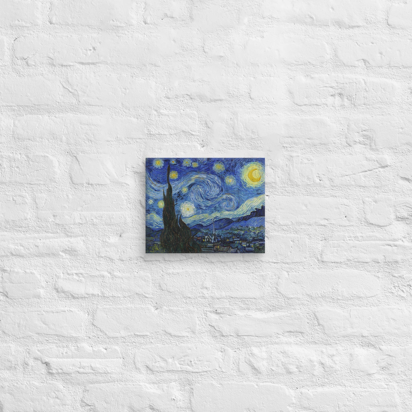Van Gogh's 'Starry Night' on a 8"x10" unframed canvas print on a white brick wall.