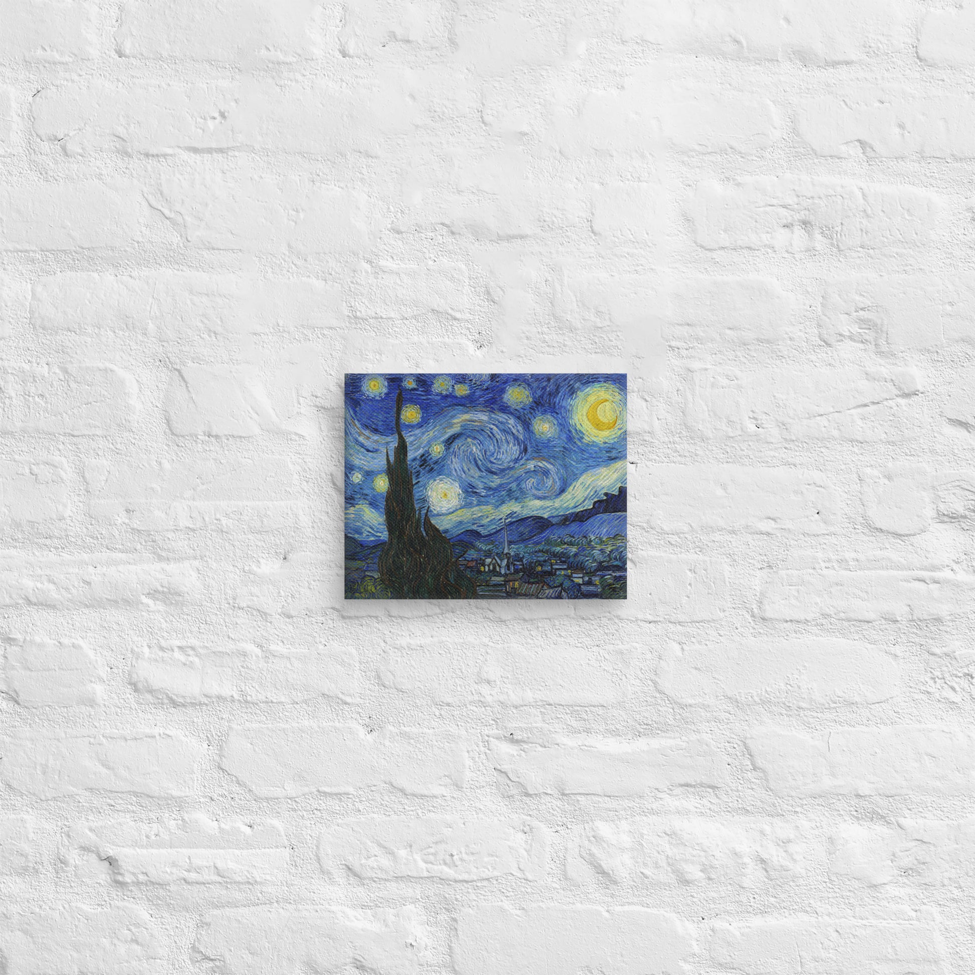 Van Gogh's 'Starry Night' on a 8"x10" unframed canvas print on a white brick wall.